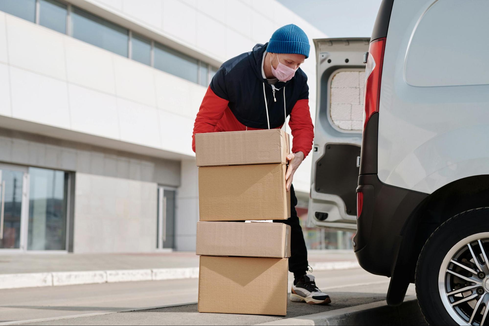 A delivery man loads packages into a van – Slotted